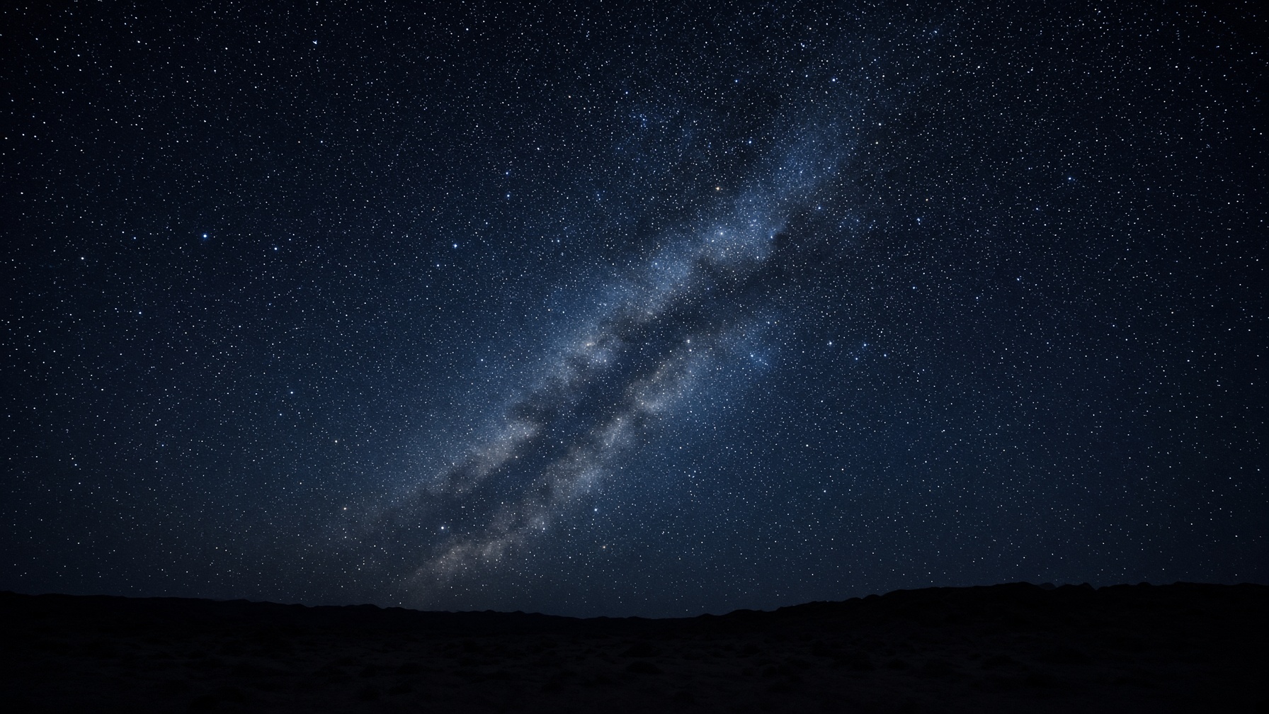 The Milky Way over a dark ridgeline. Look up.