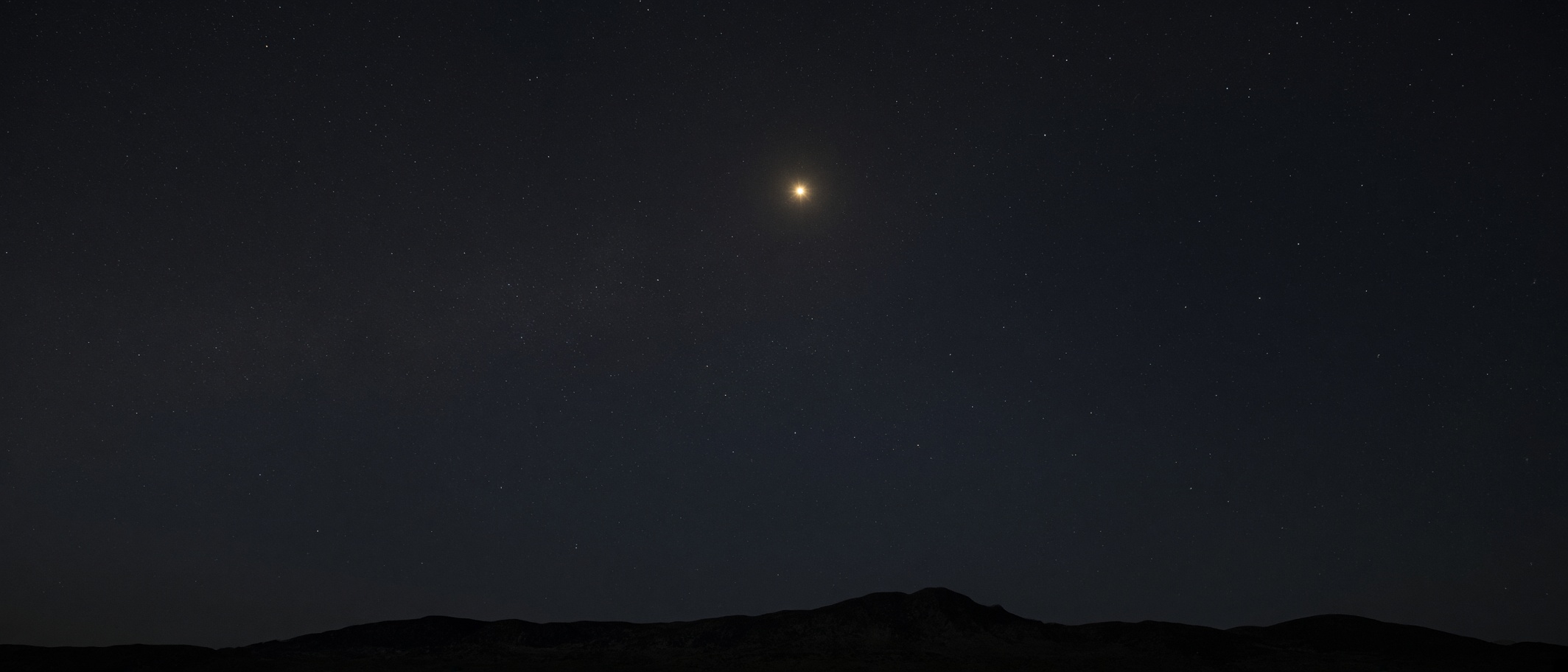 Polaris as a high north lamp over a dark horizon. The axis made visible.